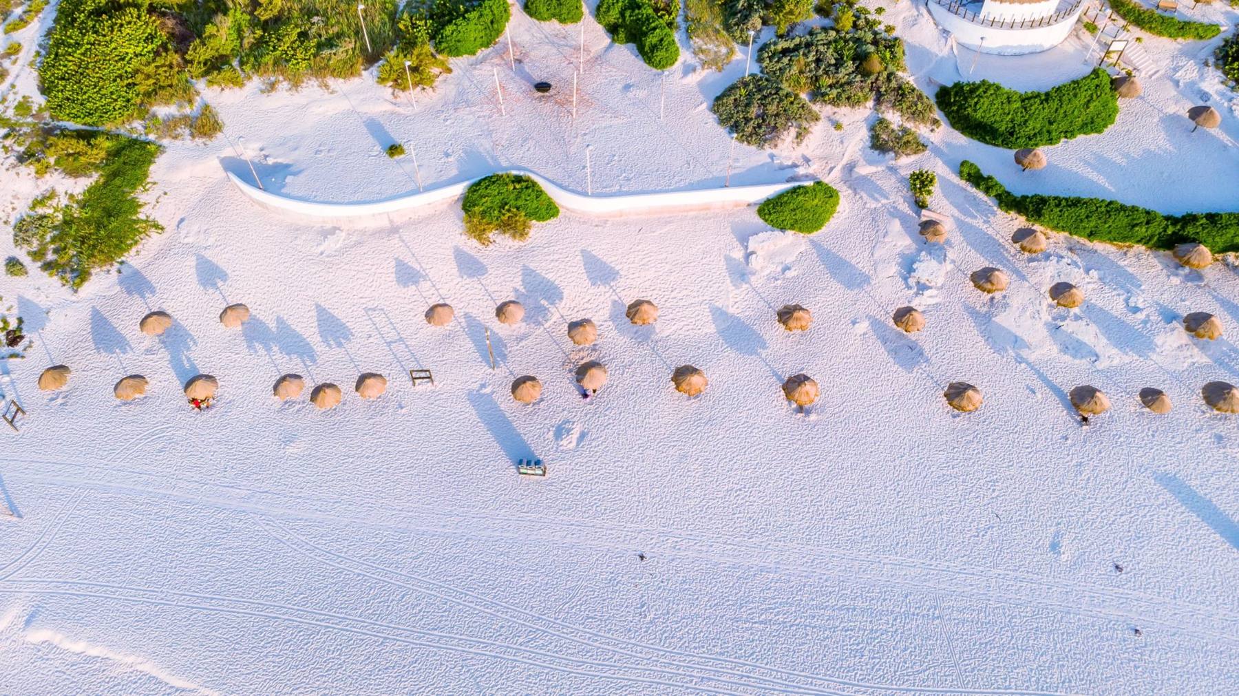 Vista aérea de playa con palapas en Cancún